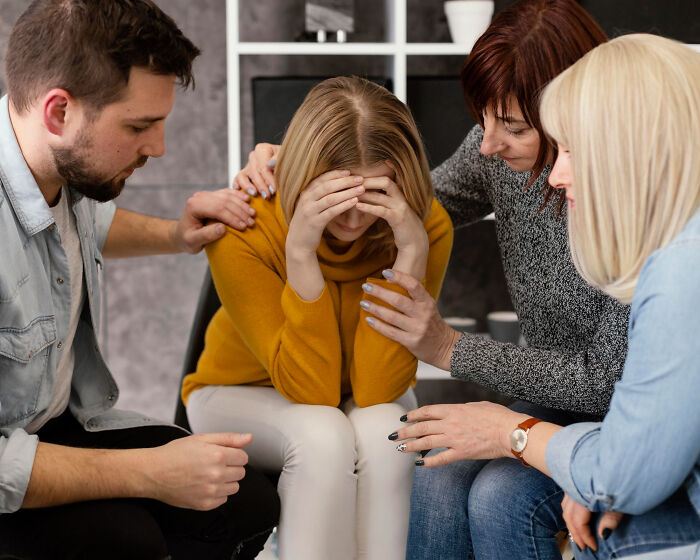 Group comforting distressed woman, highlighting effects of meeting a psychopath