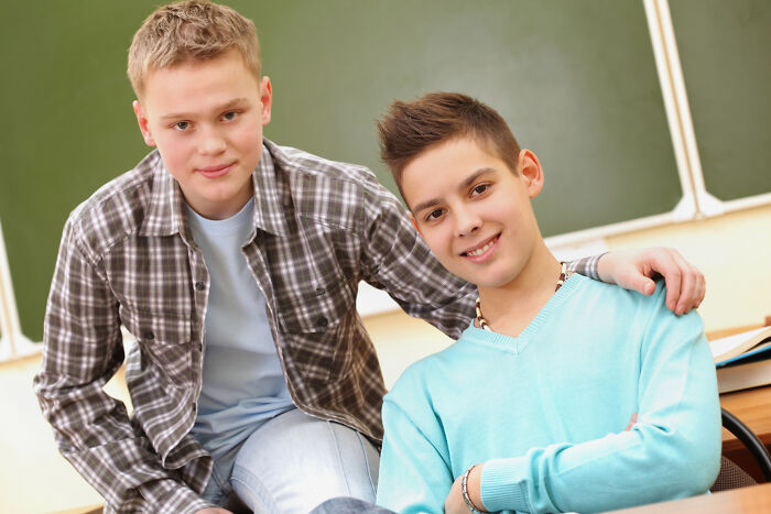 Two teenage boys smiling in classroom illustrating meeting a psychopath