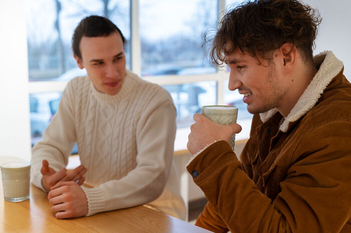 Two men in intense dialogue over coffee, illustrating meeting a psychopath