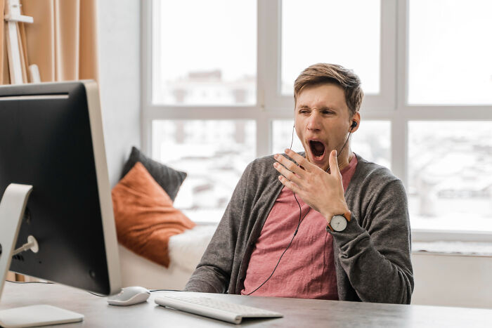 Man yawning at computer screen showing signs of psychopath traits