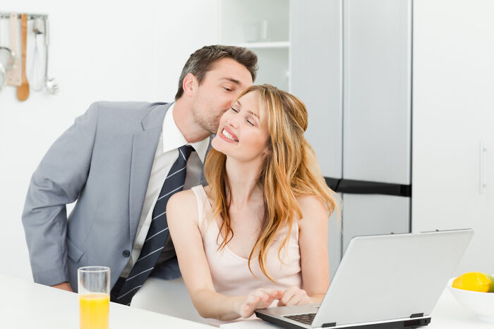 Man with psychopath behavior kissing woman uncomfortably at laptop