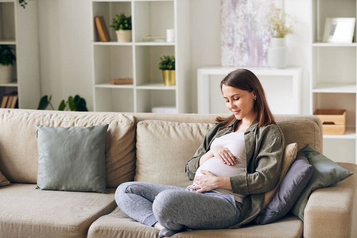 Pregnant woman sitting on couch reflecting on psychopath traits