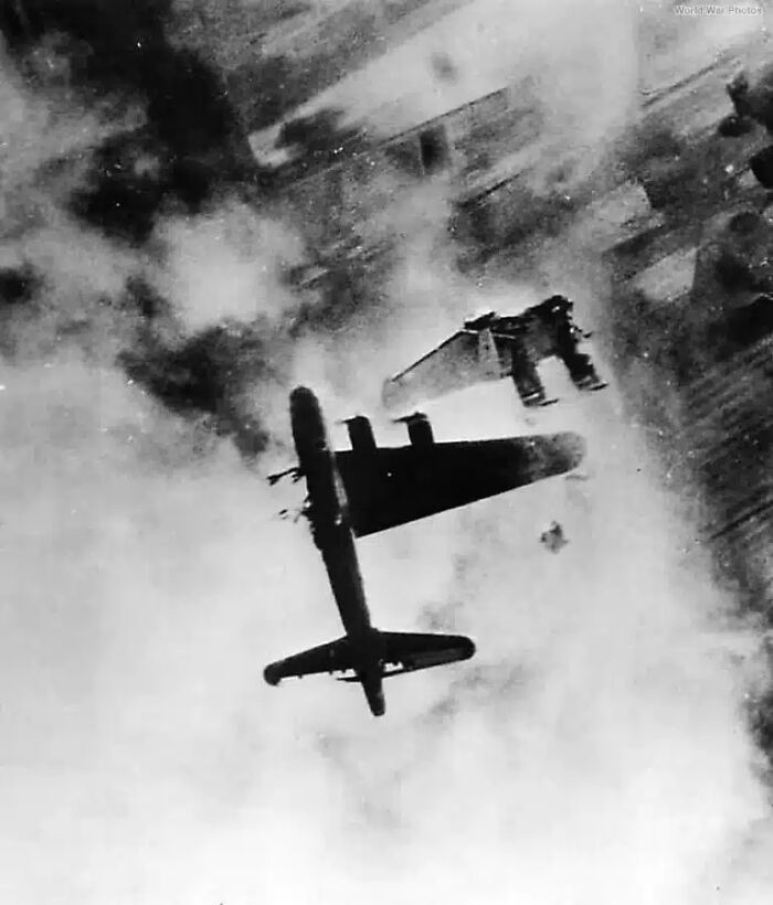 Two airplanes in mid-air, one in pieces, against a cloudy sky, one of many historical photos.