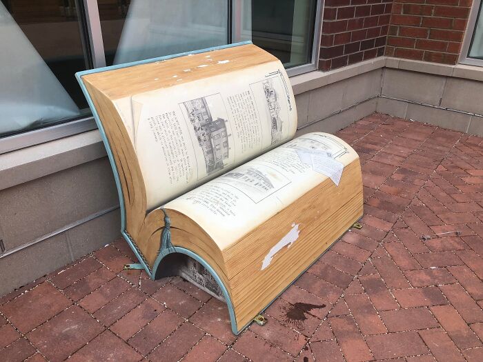 Book-shaped outdoor bench with pages and cover details in urban setting unique furniture design