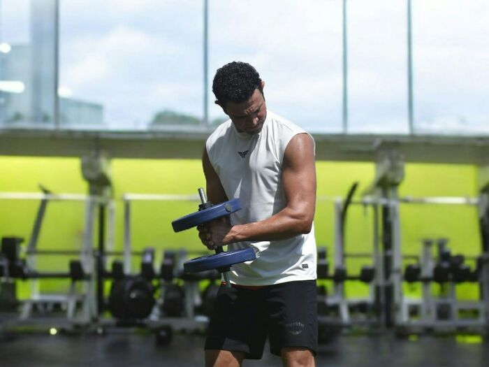 Man lifting weights at gym for self-improvement after cheating