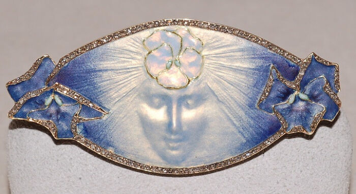 Art Nouveau brooch featuring a delicate face and blue enamel, an interesting object still intact.