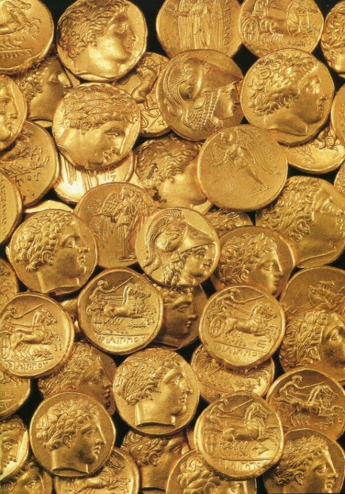 Pile of ancient gold coins with various engraved profiles, intact objects from many years ago.
