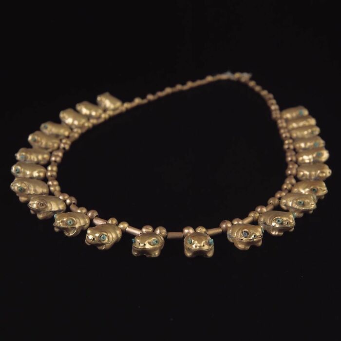 Gold necklace with frog-shaped beads and turquoise eyes, an interesting object still intact after all these years.