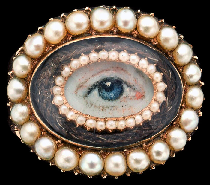Oval brooch with a painted eye surrounded by pearls, an interesting object that is still intact.