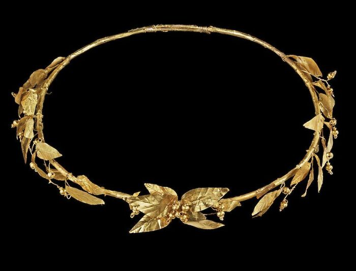 Gold wreath with intricate leaf and berry details, an intact object from ancient times.