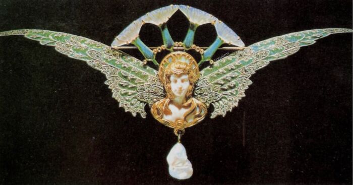 Elaborate Art Nouveau brooch featuring a winged figure and pearl drop, an intact object of beauty.