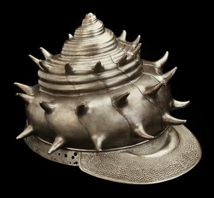 An intricately designed silver helmet in the shape of a spiked shell, remarkably intact after all these years, an interesting object.