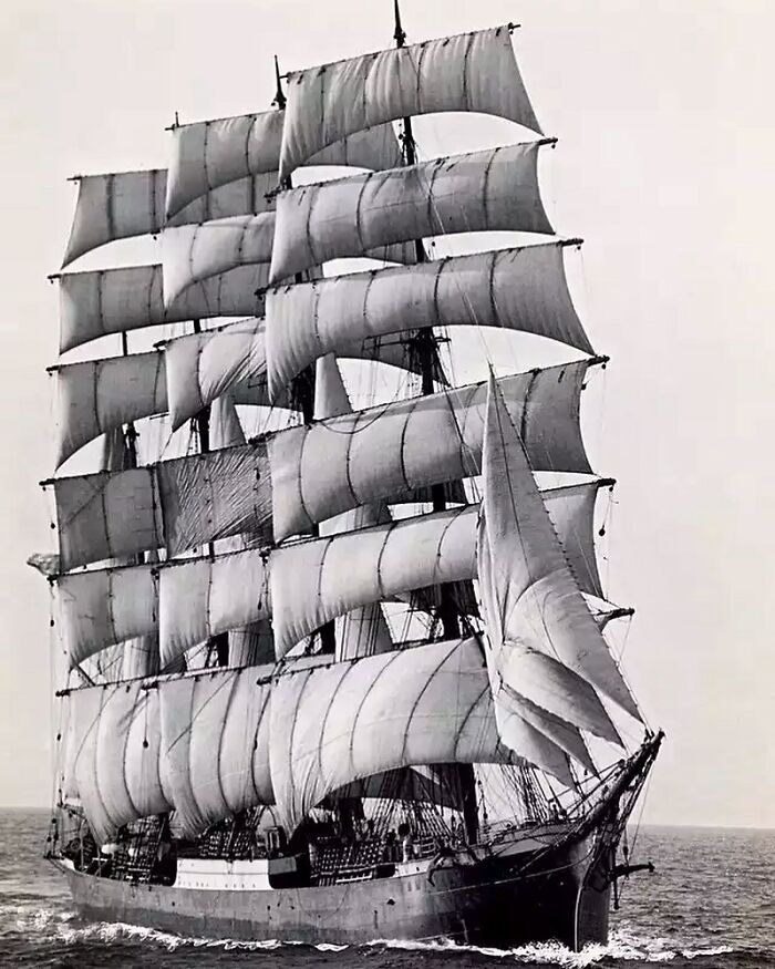 A majestic sailing ship with full sails on the open ocean, an interesting historical photo.