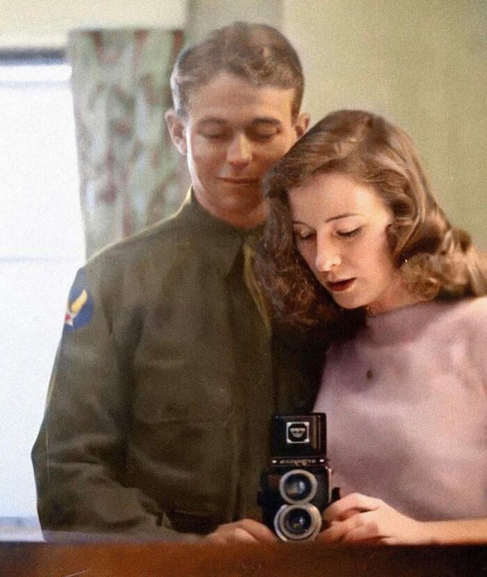 A couple in vintage attire takes a selfie, capturing a moment for rare and interesting historical photos.