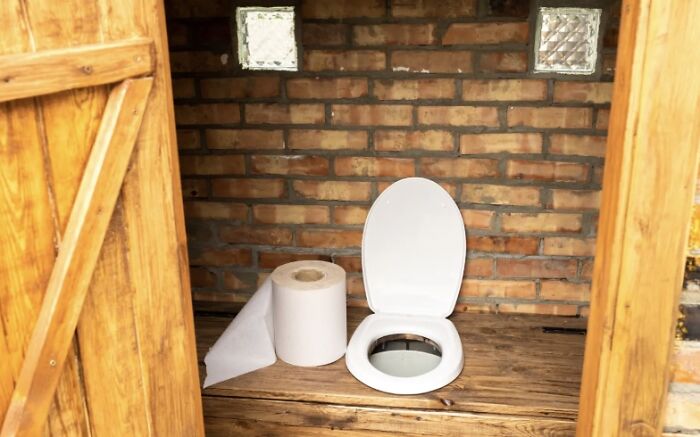 An outdoor toilet made of wood and brick, a real estate listing that should come with a trigger warning.