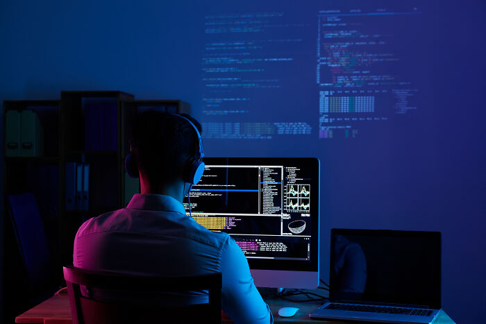 Man coding at a computer, representing jobs safe from AI's impact.