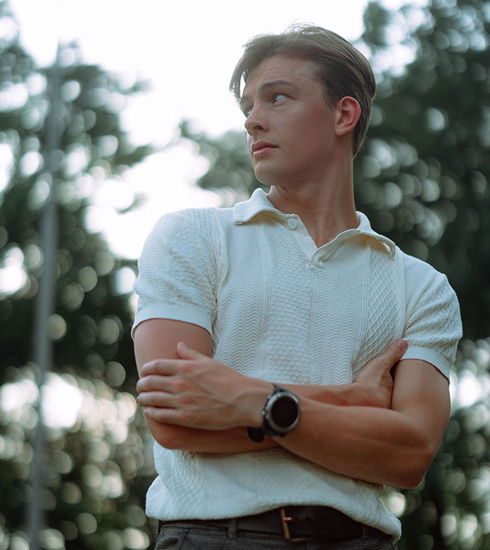 A young man looking sideways, arms crossed, embodying true crime fans realizing something was seriously wrong.