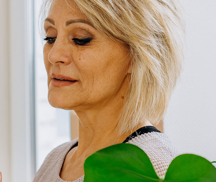 A thoughtful woman with short blonde hair looks down, realizing something was seriously wrong.
