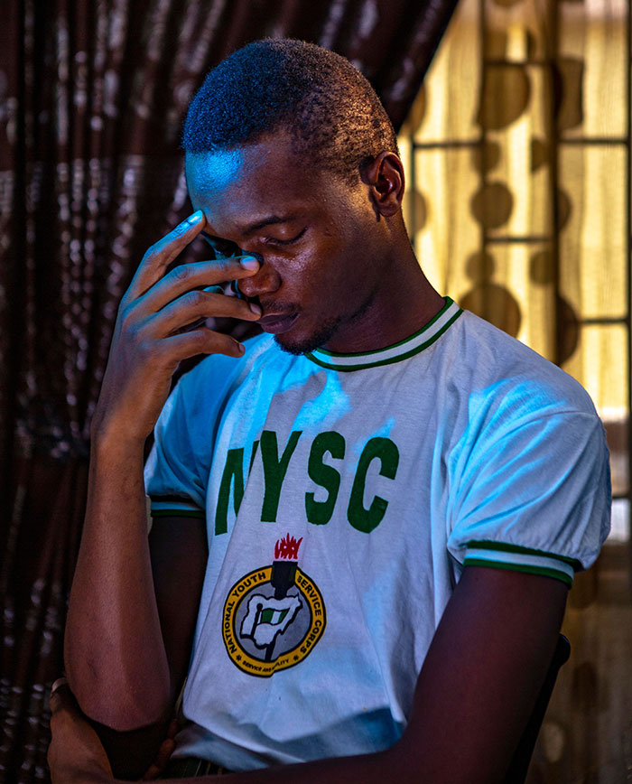 A man in an NYSC shirt looking distressed, realizing something was seriously wrong.