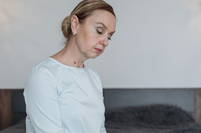 A pensive woman looking down, symbolizing true crime fans realizing something was seriously wrong.