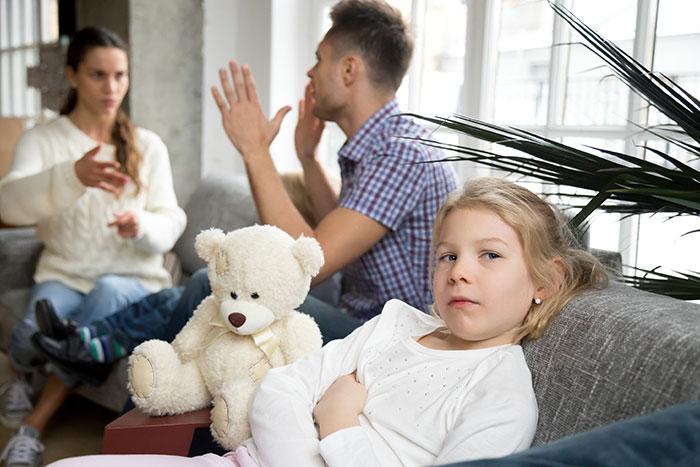 Parents arguing while child looks upset about health issues Parents arguing while child looks upset about health issues