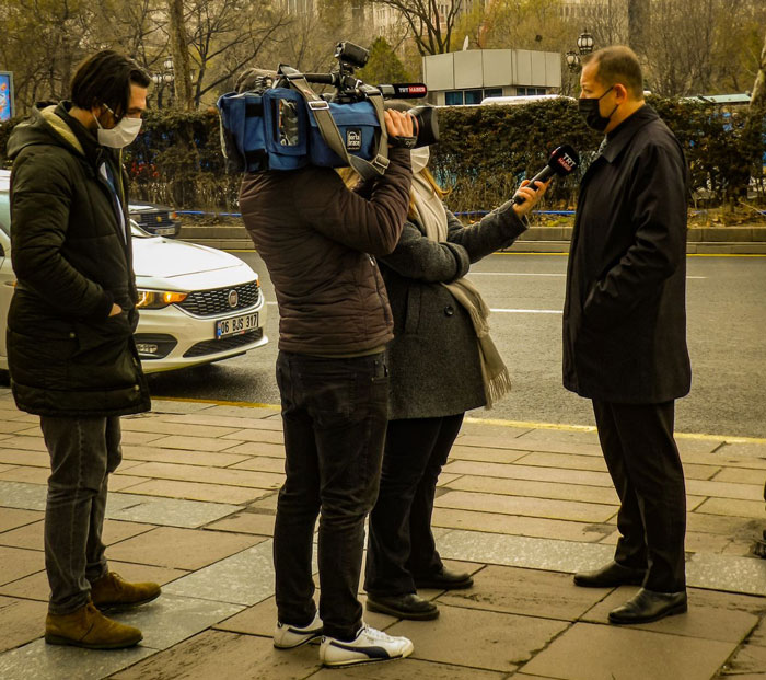 A restaurant employee being interviewed by media outlets, exposing the scam