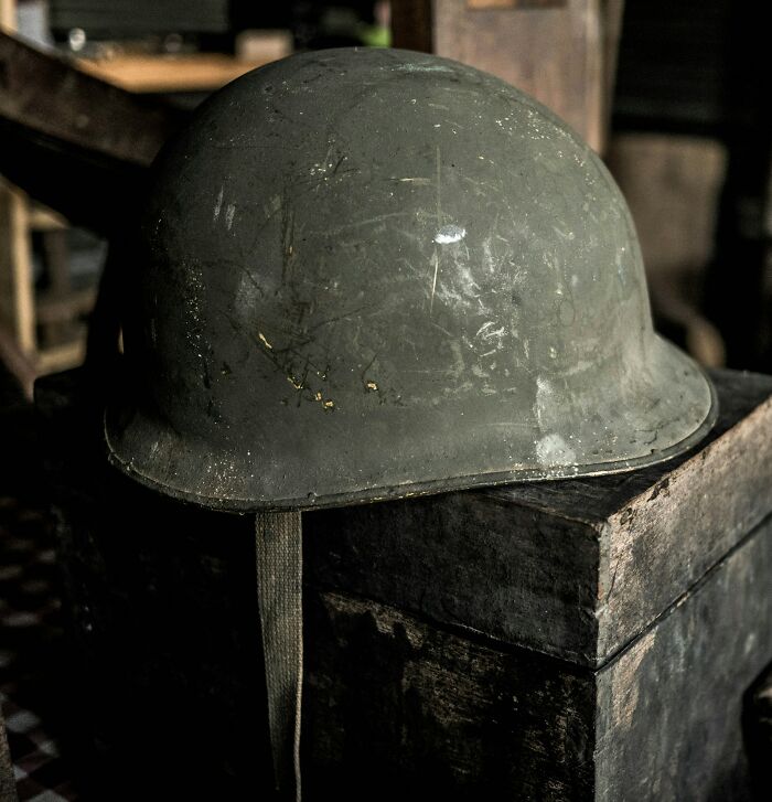 A worn military helmet resting on a wooden crate, highlighting crazy facts and Wyoming escalators.