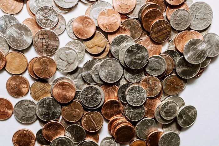 Varied coins scattered symbolizing economic context of Gen Alpha illiteracy