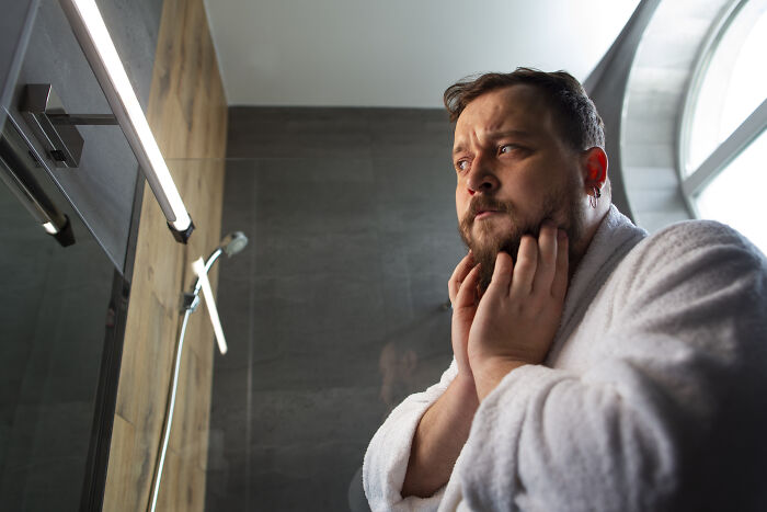 Man in bathrobe worried looking in mirror petty revenge
