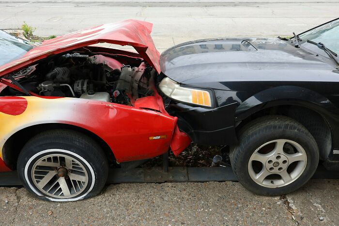 Red and black cars with front-end collision damage