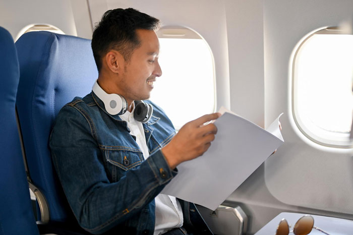 Passenger reading by window on flight with seat light dispute Passenger reading by window on flight with seat light dispute