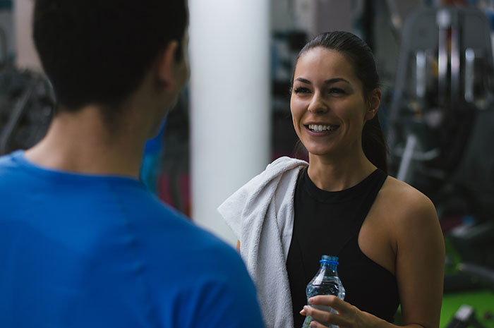 A smiling woman talking at the gym, representing shared secrets people keep.