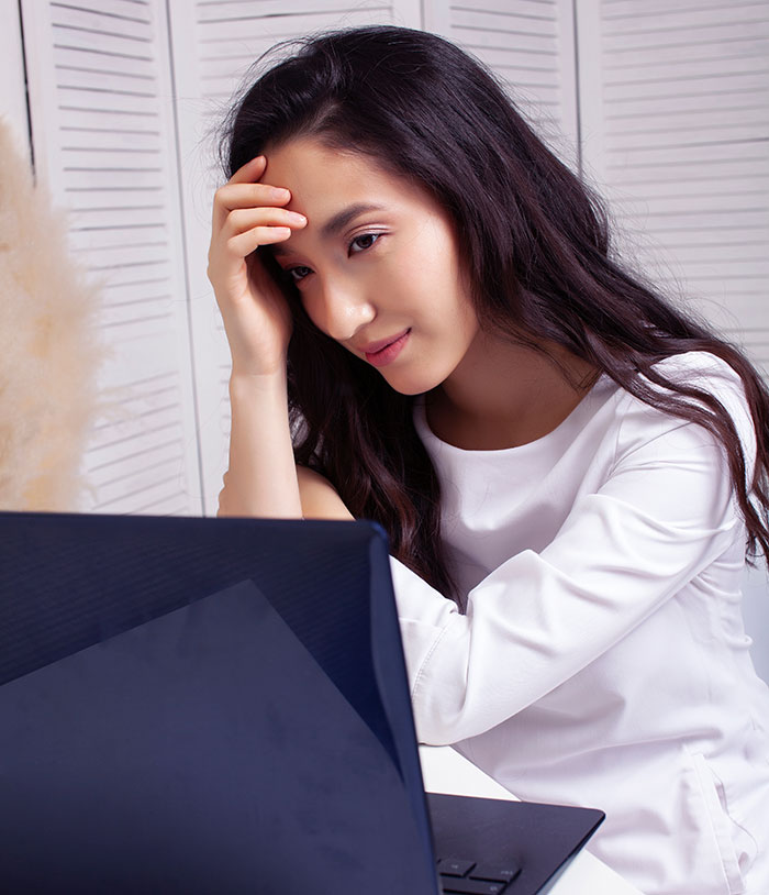 A woman looking at a laptop with a worried expression, potentially dealing with secrets people keep to themselves.