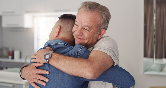 Two men hugging, portraying the emotional impact of secrets people keep to themselves.