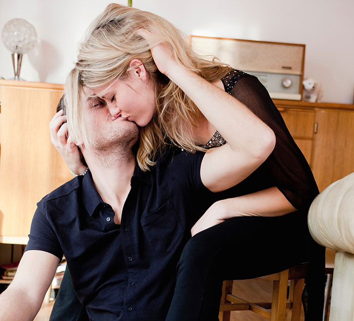A couple sharing a secret kiss, illustrating the topic of secrets people keep about others.