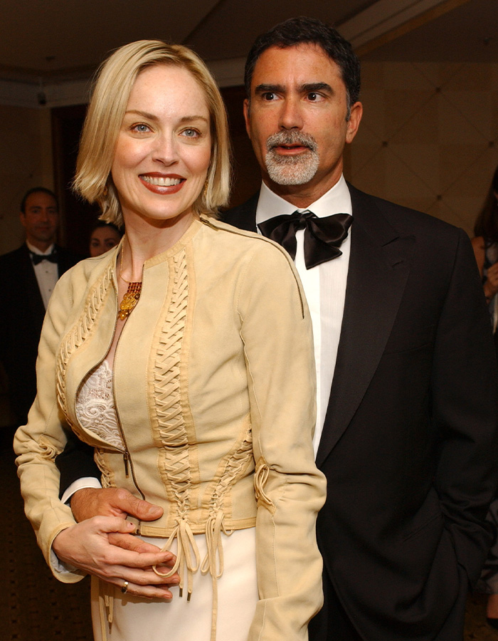 Sharon Stone with her husband at a formal event smiling and posing together