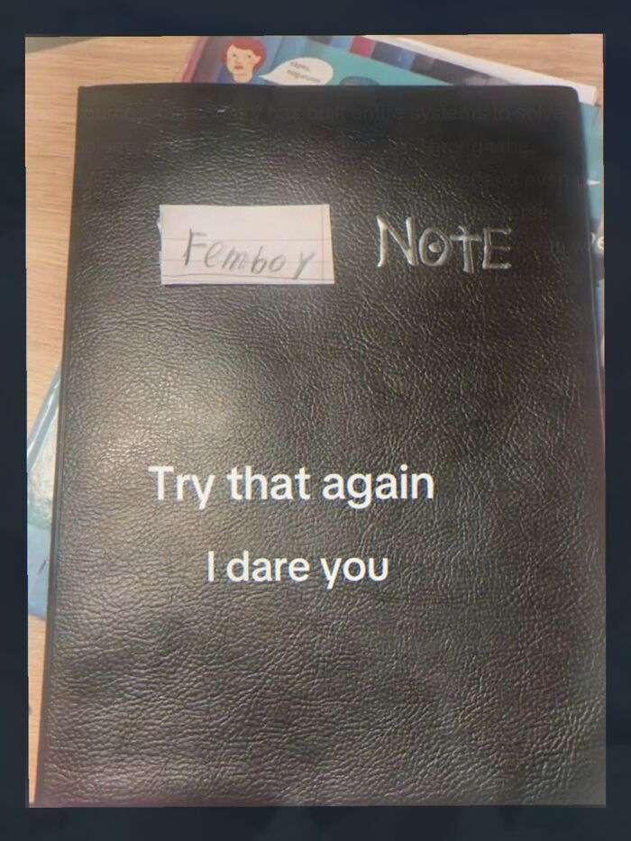 Black notebook labeled femboy note with text dare to try again