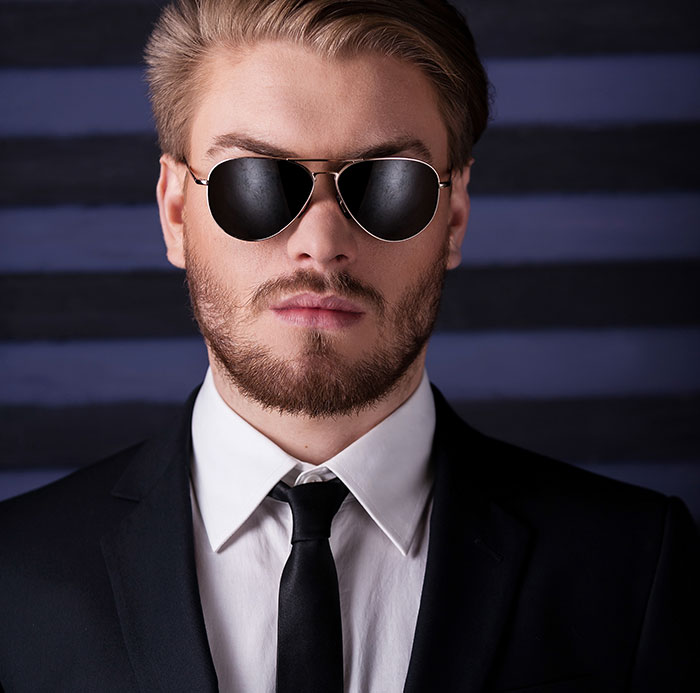 Portrait of stylish man in suit and sunglasses representing smooth criminals