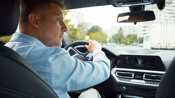 Man driving a car focused on road symbolizing smooth criminals