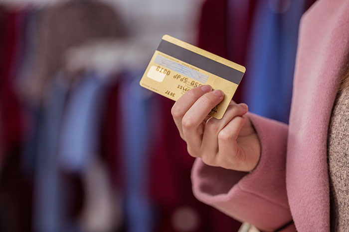 Person holding credit card in hand inside store