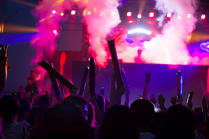 Crowd enjoying concert with colorful lights embodying smooth criminals