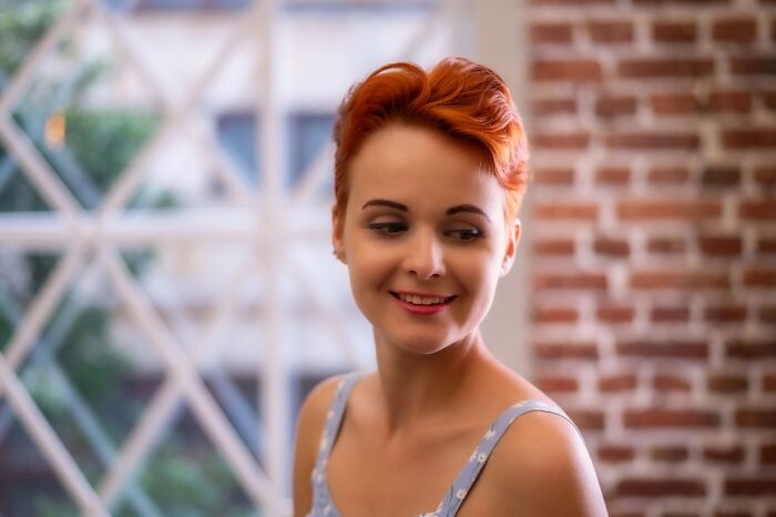 Happy bride with short red hair smiling indoors