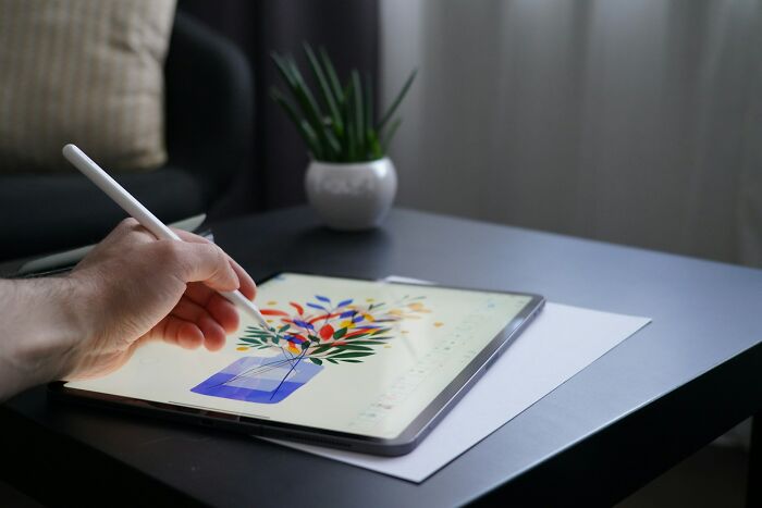 A person with an unusual job, drawing on a tablet with a stylus, showcasing the diverse nature of unusual jobs.
