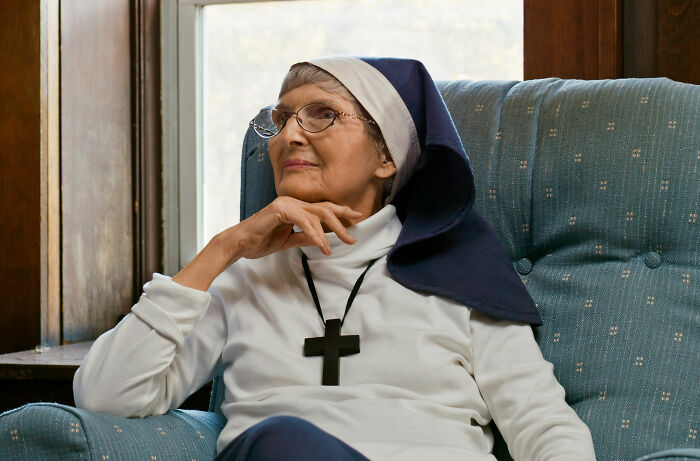 Elderly nun in hospital setting reflecting on medical stories
