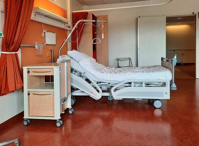 Empty hospital bed and medical equipment in patient room