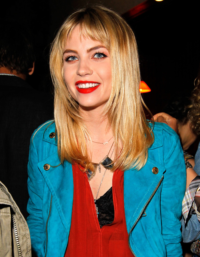 Blonde actress from The Ring and Lilo & Stitch, Nicki Aycox, smiles wearing a red top and blue jacket. She passed away at 35.