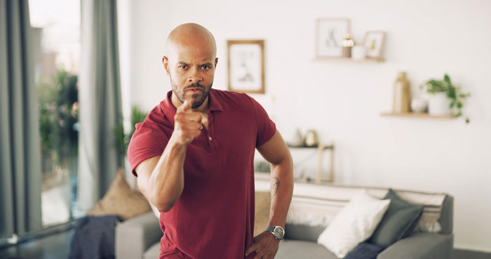 A man with a serious expression, pointing his finger, enforcing house rules on his stepdaughter. A man with a serious expression, pointing his finger, enforcing house rules on his stepdaughter.