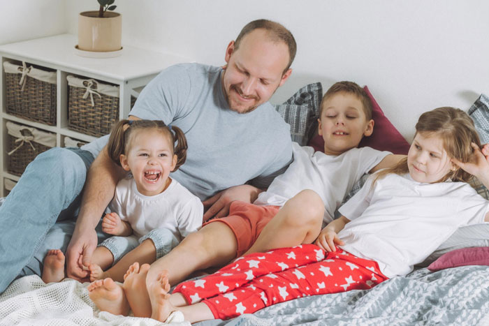 Father spending quality time with kids on bed family safety and support