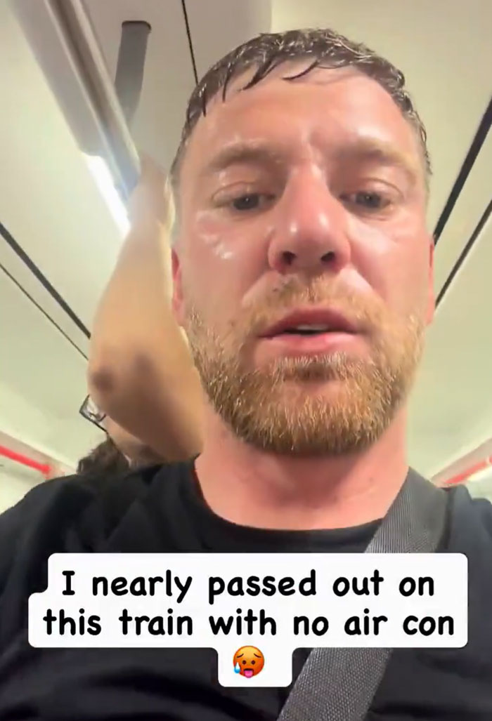 A sweaty European man on a train with no air conditioning, trying to survive the heatwave.
