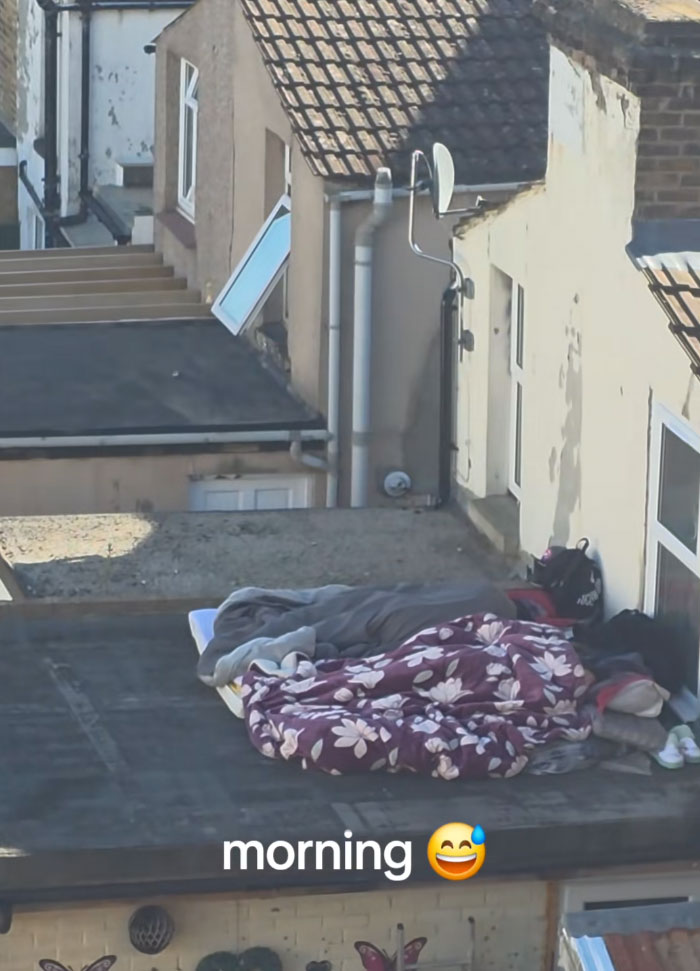 A European sleeping on a rooftop with blankets to escape the extreme heatwave.